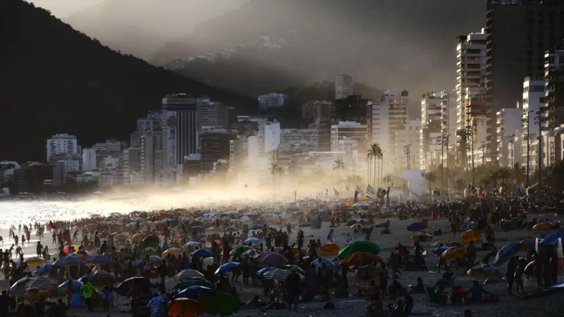 people enjoying sunset at crowded Ipanema Beach Rio