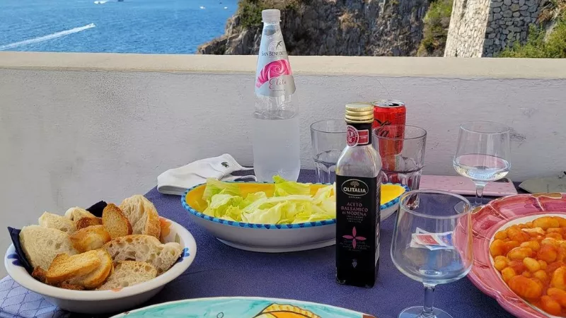Amalfi Coast local cuisine with bread, salad, olives and sea view dining