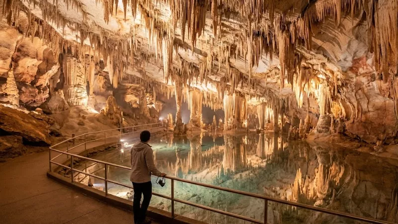 Visitor admiring the mirror reflection of stalactites in Dream Lake inside Luray Caverns early in the morning before tour groups arrive