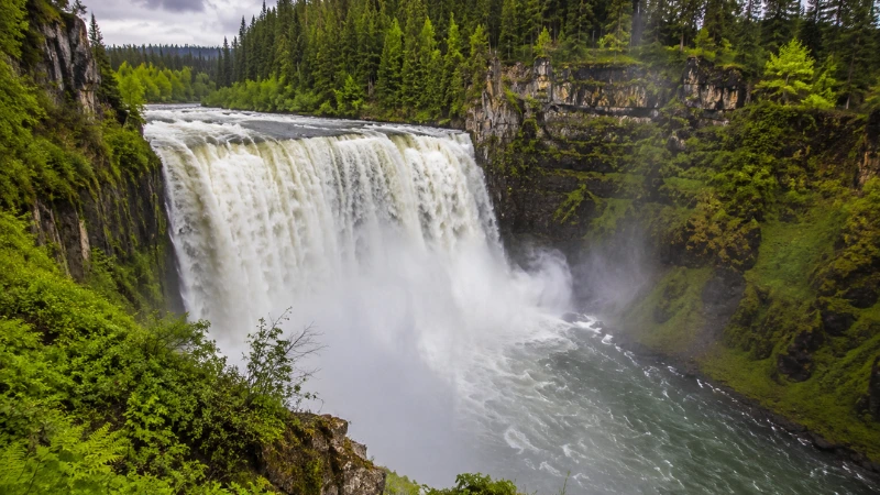 Upper Mesa Falls in Island Park Idaho at peak spring runoff with powerful whitewater and lush green canyon walls