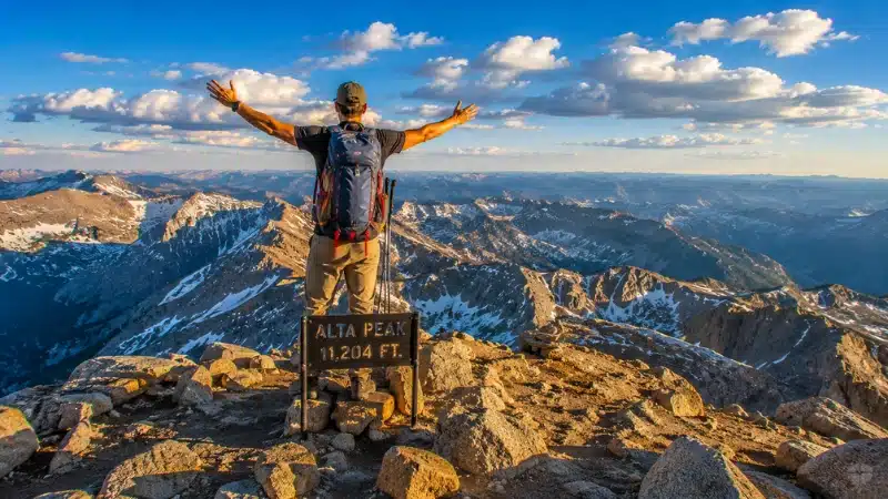 Hiker at Alta Peak summit with panoramic Sierra Nevada view in Sequoia National Park