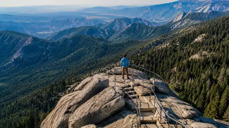 Hiker at the top of Moro Rock looking over Sierra Nevada ridges on a one day Sequoia itinerary